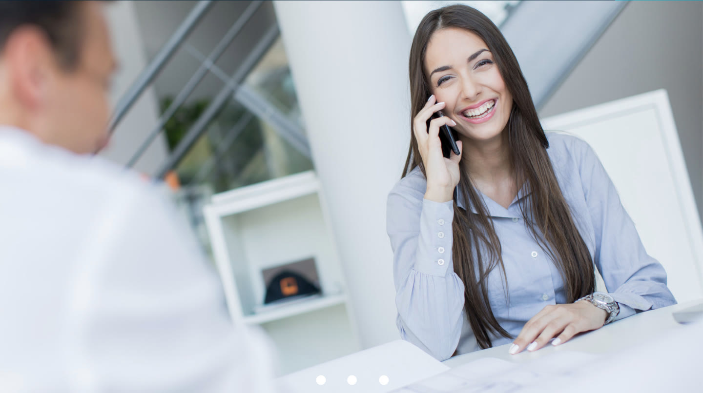 Ejecutiva de Inmobiliaria FG atendiendo a un cliente por teléfono